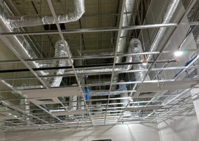 Unfinished interior space with exposed ceiling showing ductwork, wiring, and structural elements.